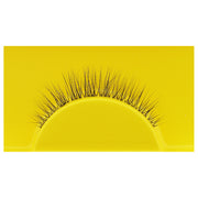 A single Boldface Lashes - Short and Sweet false eyelash rests on a vibrant yellow background. This cruelty-free beauty by Boldface showcases fine, evenly spaced black fibers arranged in a natural curve, enhancing the appearance of eyelashes when worn while ensuring this accessory is both captivating and kind.